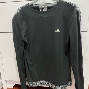 Black Adidas shirt with “three strip life” written in sleeve and bottom of shirt